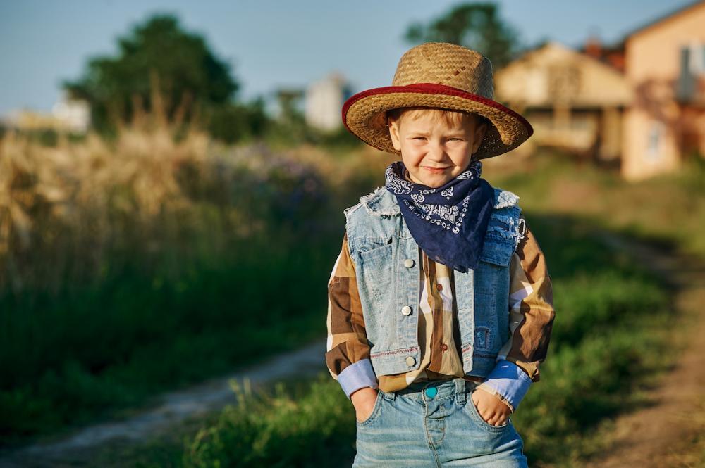 A boy wearing a straw hat and bandana