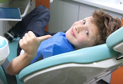 A child giving a thumbs-up at the dentist