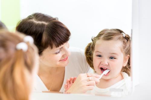 A mother brushing her baby's teeth
