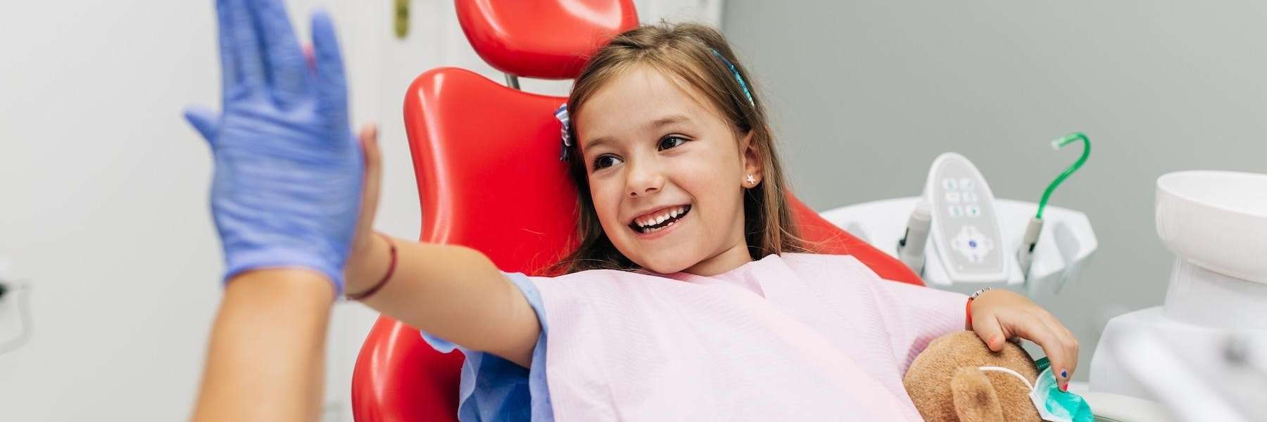 A little girl giving her dentist a high five