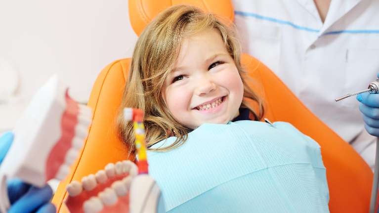 A smiling child getting a dental exam in Weatherford, TX